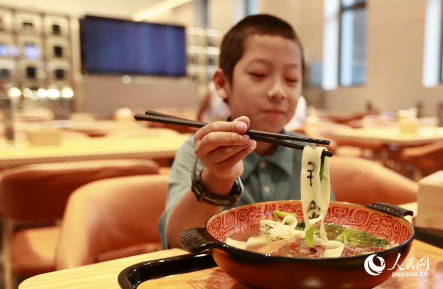 殷墟博物館推出的甲骨文面深受游客喜愛。人民網(wǎng)記者 慎志遠(yuǎn) 攝