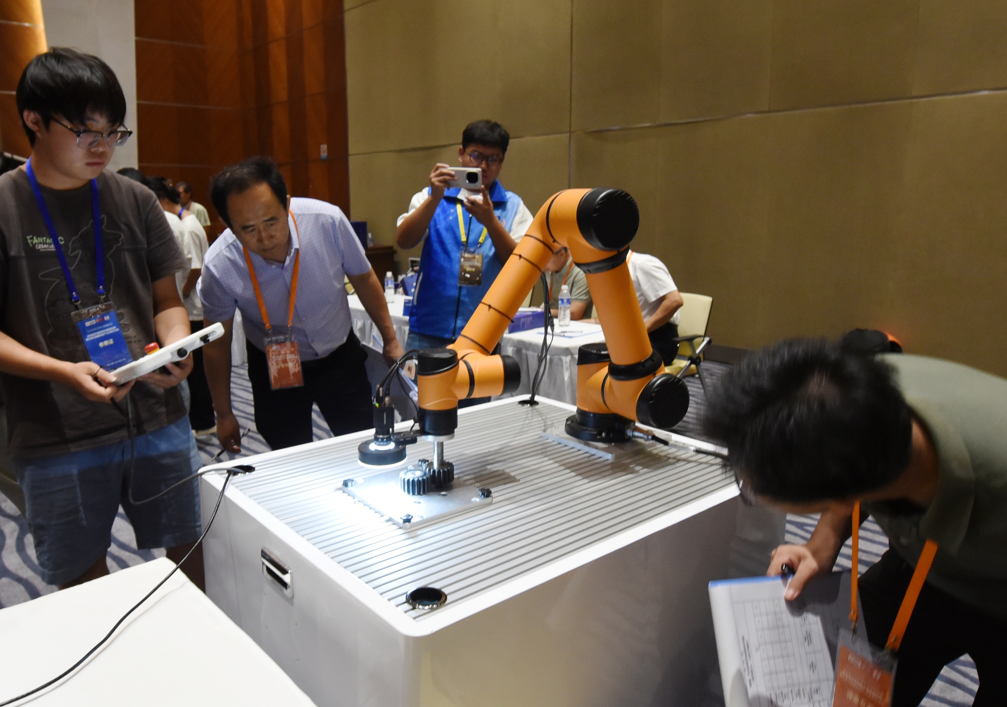 2025年中國(guó)大學(xué)生機(jī)械工程創(chuàng)新創(chuàng)意大賽智能精密裝配賽京津冀魯聯(lián)賽現(xiàn)場(chǎng)，評(píng)委對(duì)參賽選手進(jìn)行實(shí)操調(diào)試評(píng)比。